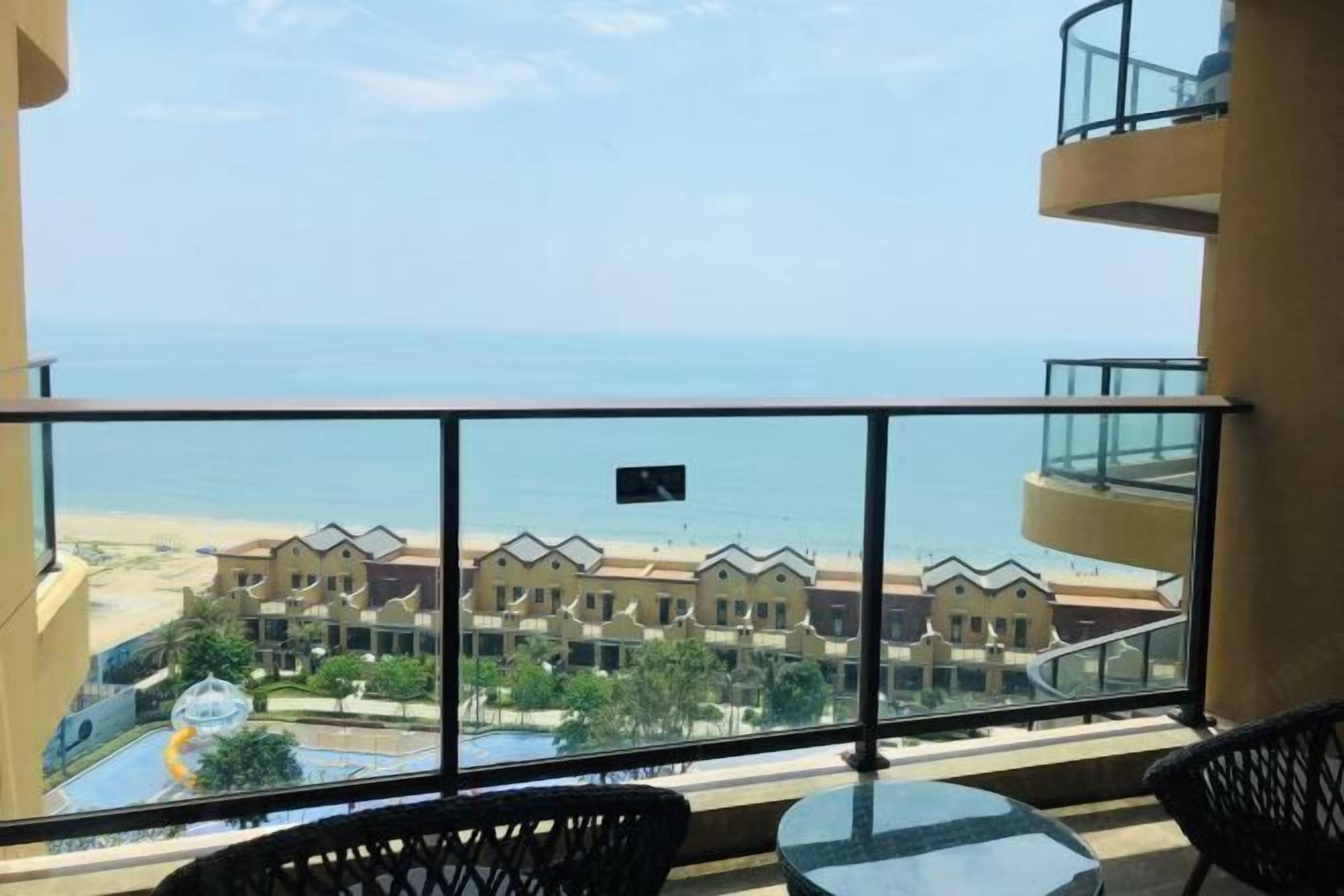 Uma varanda com vista para o mar e edifícios do resort.