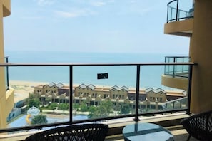 A balcony with a view of the sea and resort buildings. - Good Time Seaview Hotel (Huidong)