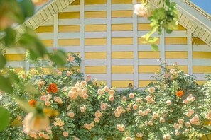 A building with a yellow facade and a grid-like pattern of windows. - Liushanmen Inn (Lijiang)