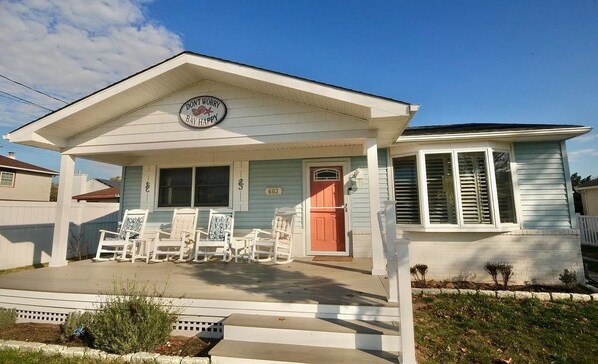 A house with a porch, a sign that says "DON'T WORRY BAY HAPPY," and a number "603" on the door. - Sunswept Bayside home in North Cape May (North Cape May)