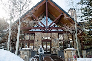 A lodge with a stone facade, wooden beams, and a large entrance. - Bear Creek Lodge by Alpine Lodging Telluride (Telluride)