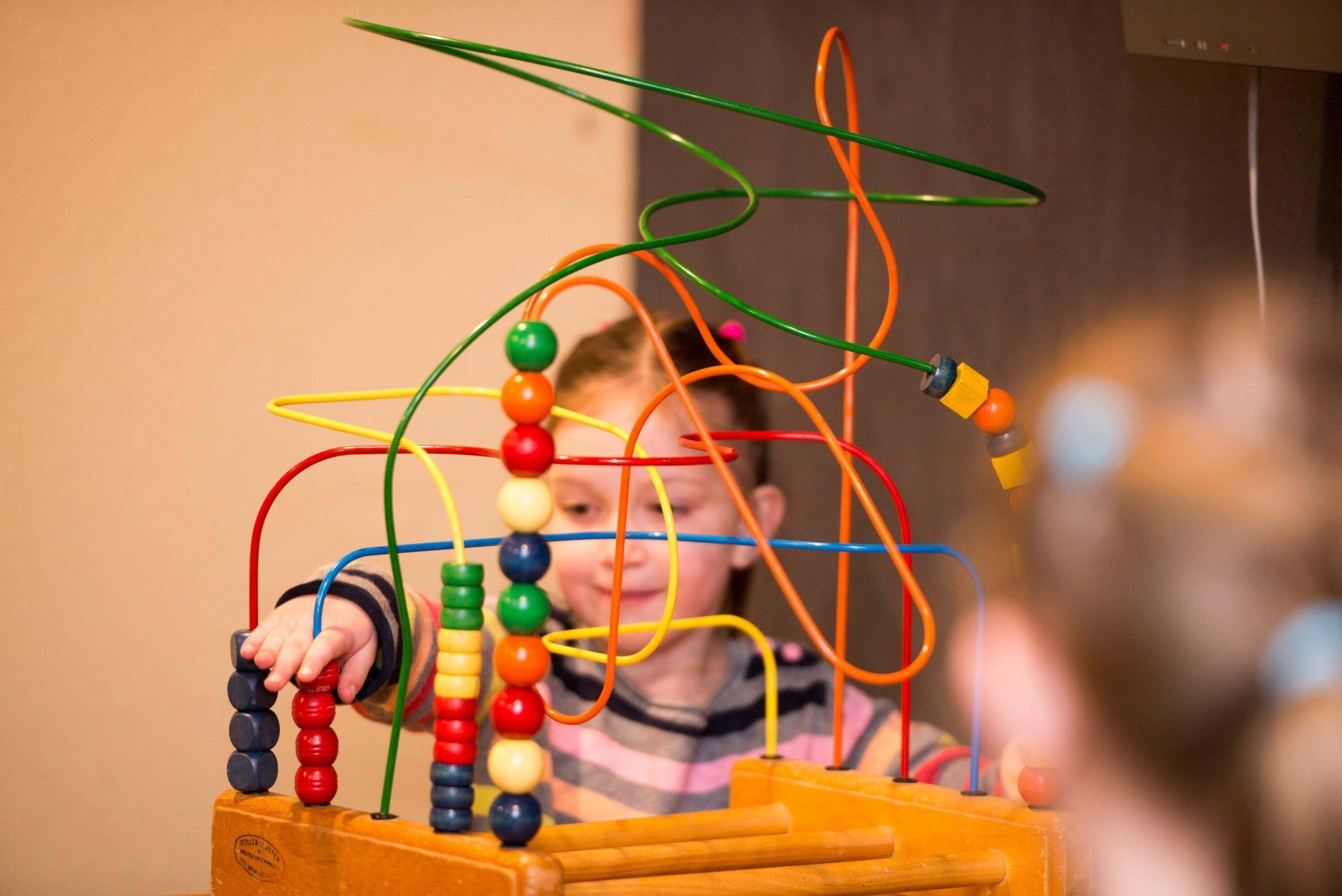 A child playing with a colorful abacus.