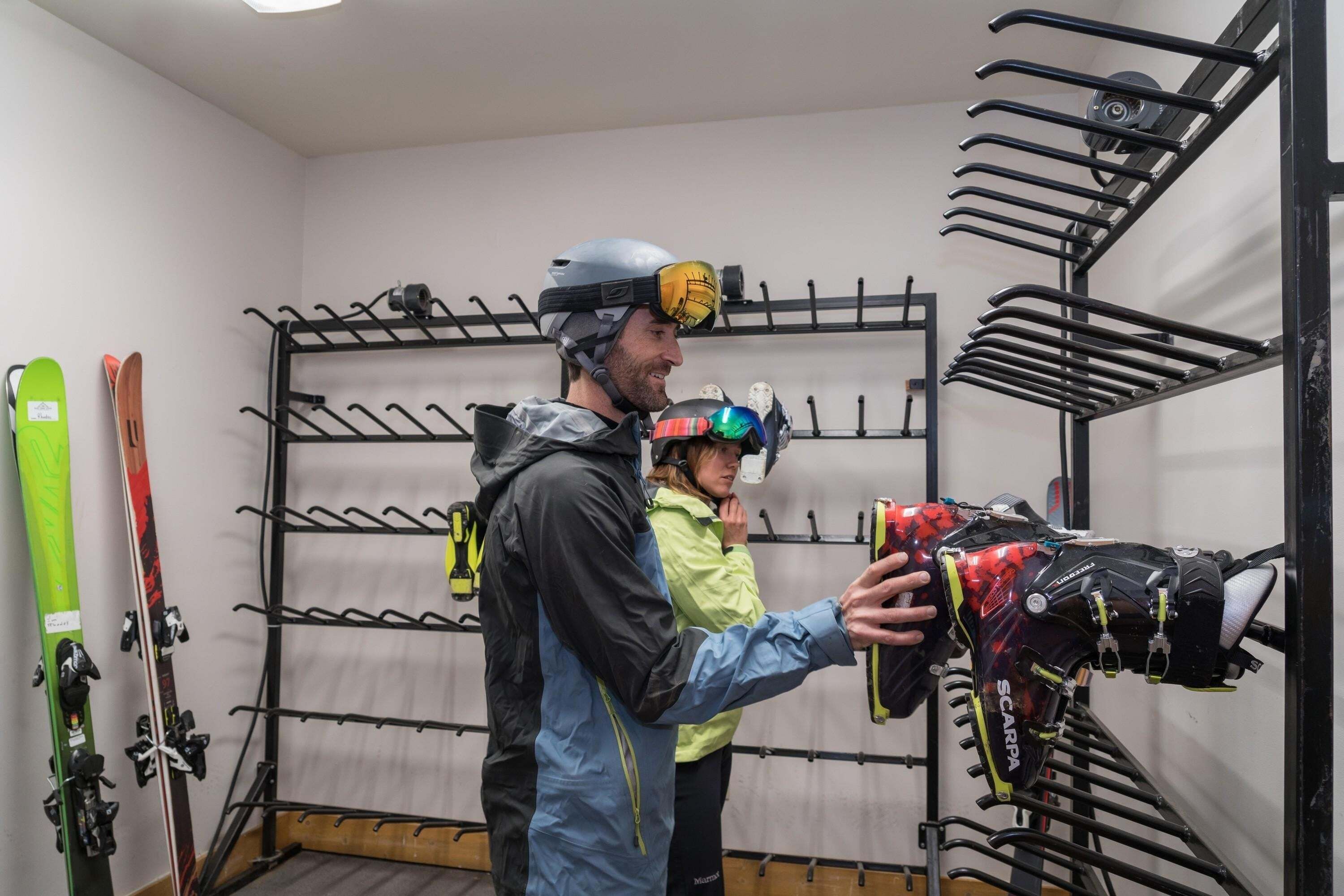 A ski storage area with multiple racks for skis and a helmet on display.