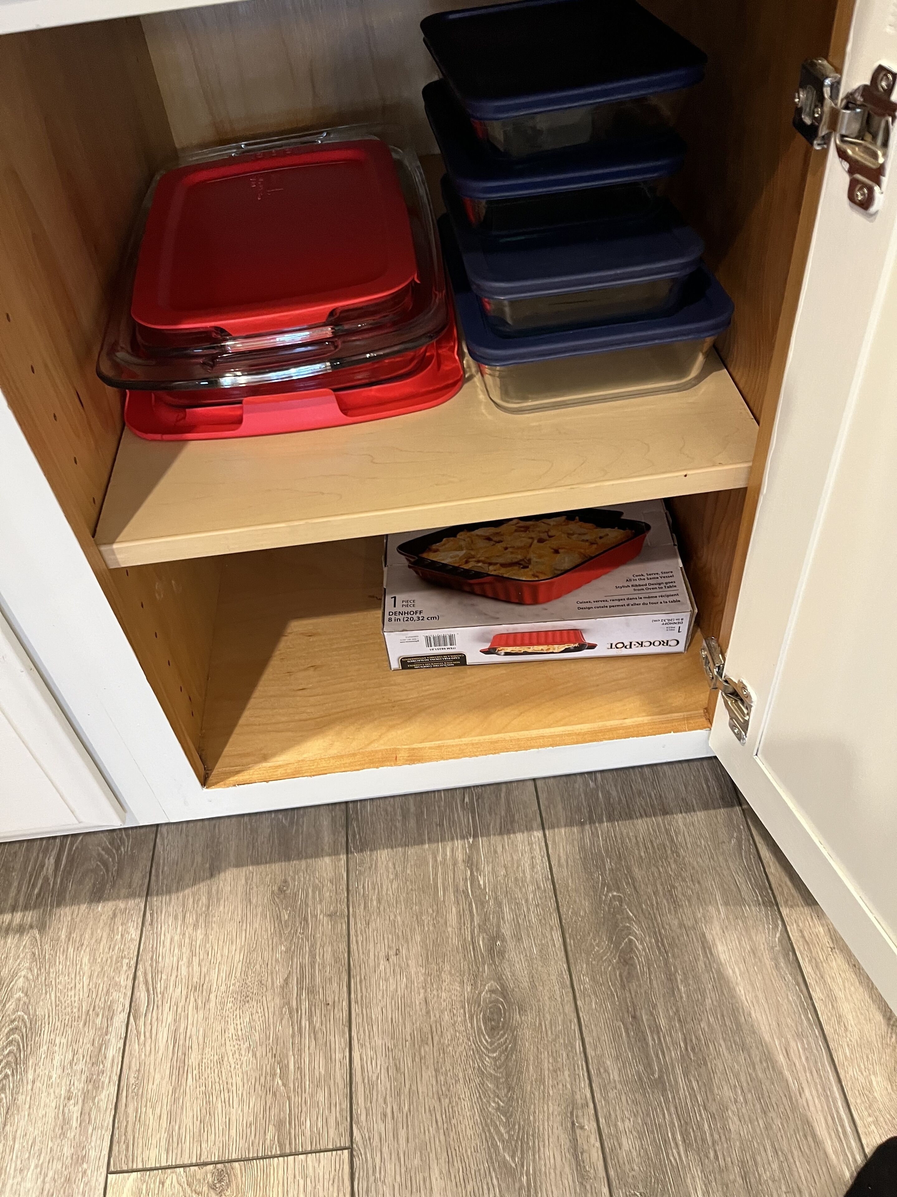 A storage cabinet with multiple compartments, including a red lid and blue containers.