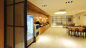 A modern restaurant with wooden paneling, a refrigerated display case, and a seating area with tables and chairs. - Mari Hotel Chungju (Chungju)