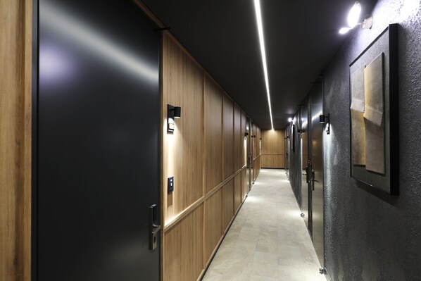 A hallway with wooden lockers, a tiled floor, and recessed lighting. - Mari Hotel Chungju (Chungju)