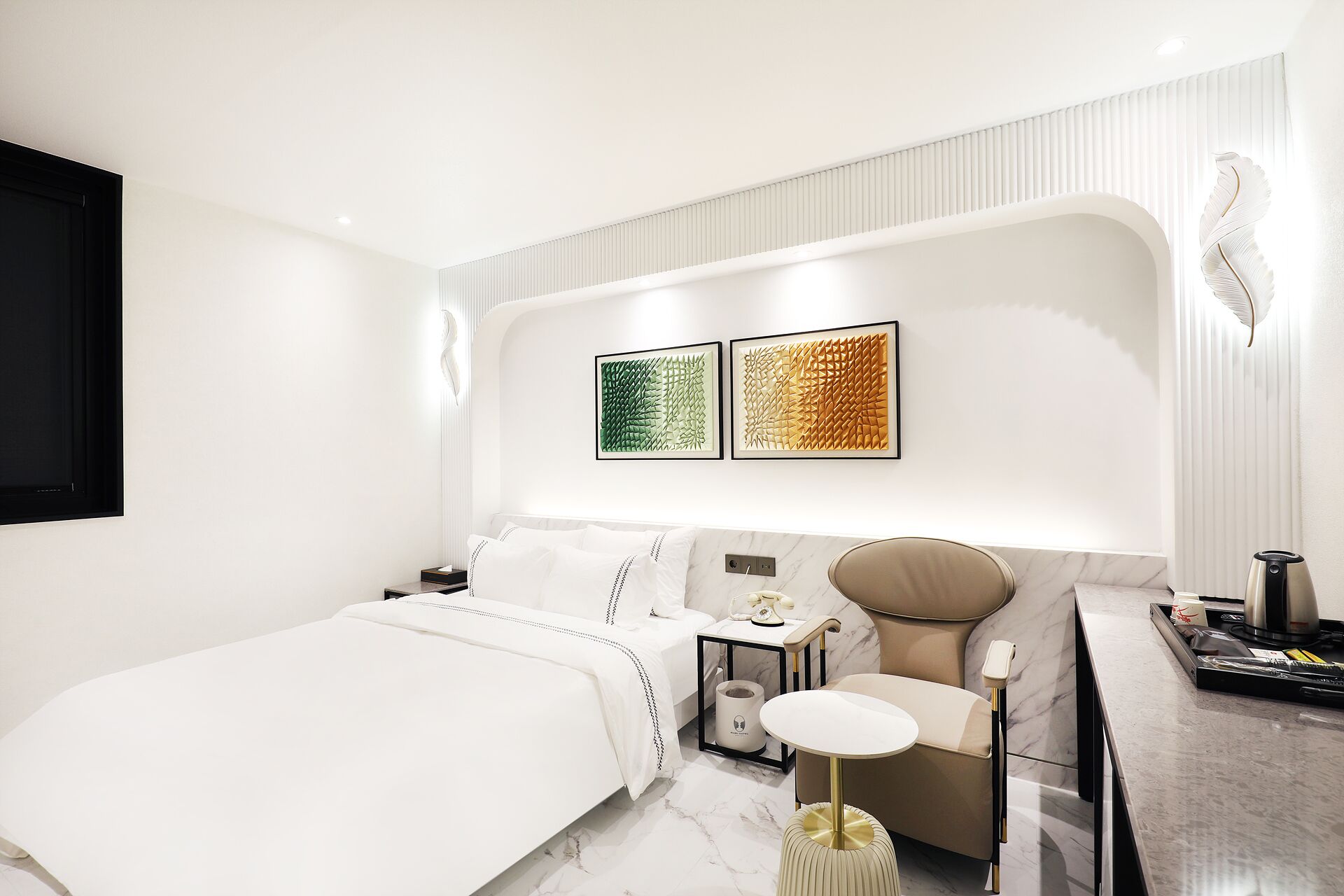 A modern bedroom with a bed, bedside table, and a vanity with a mirror.