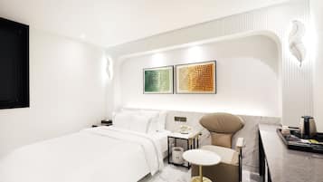 A modern bedroom with a bed, bedside table, and a vanity with a mirror.