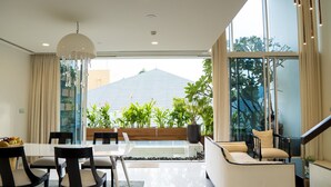 A modern dining area with a glass table, black chairs, and a white ceiling light.