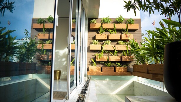 A modern balcony with wooden planters and a glass railing.