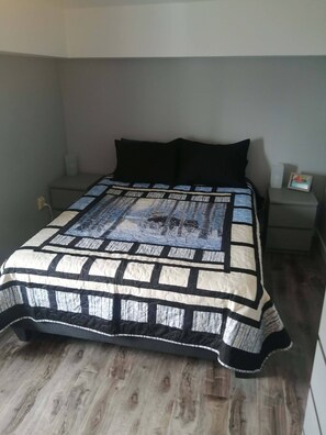 Una camera da letto con un letto, un comodino e una mensola a parete.