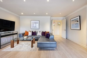 Apartamento básico, varias camas | Zona de estar | Una televisión, servicios de streaming