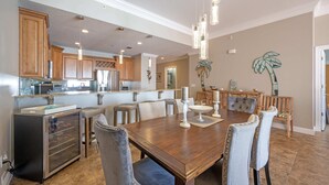 A spacious kitchen with wooden cabinets, a central island, and a dining area with a large table and chairs.