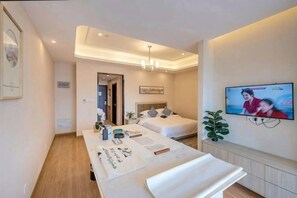 Een hotelkamer met een bed, nachtkastje, televisie en een kleine plant.