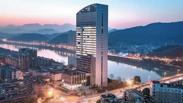 Ein Hochhaus mit moderner Architektur, gelegen in der Nähe von Wasser und umgeben von anderen Gebäuden.