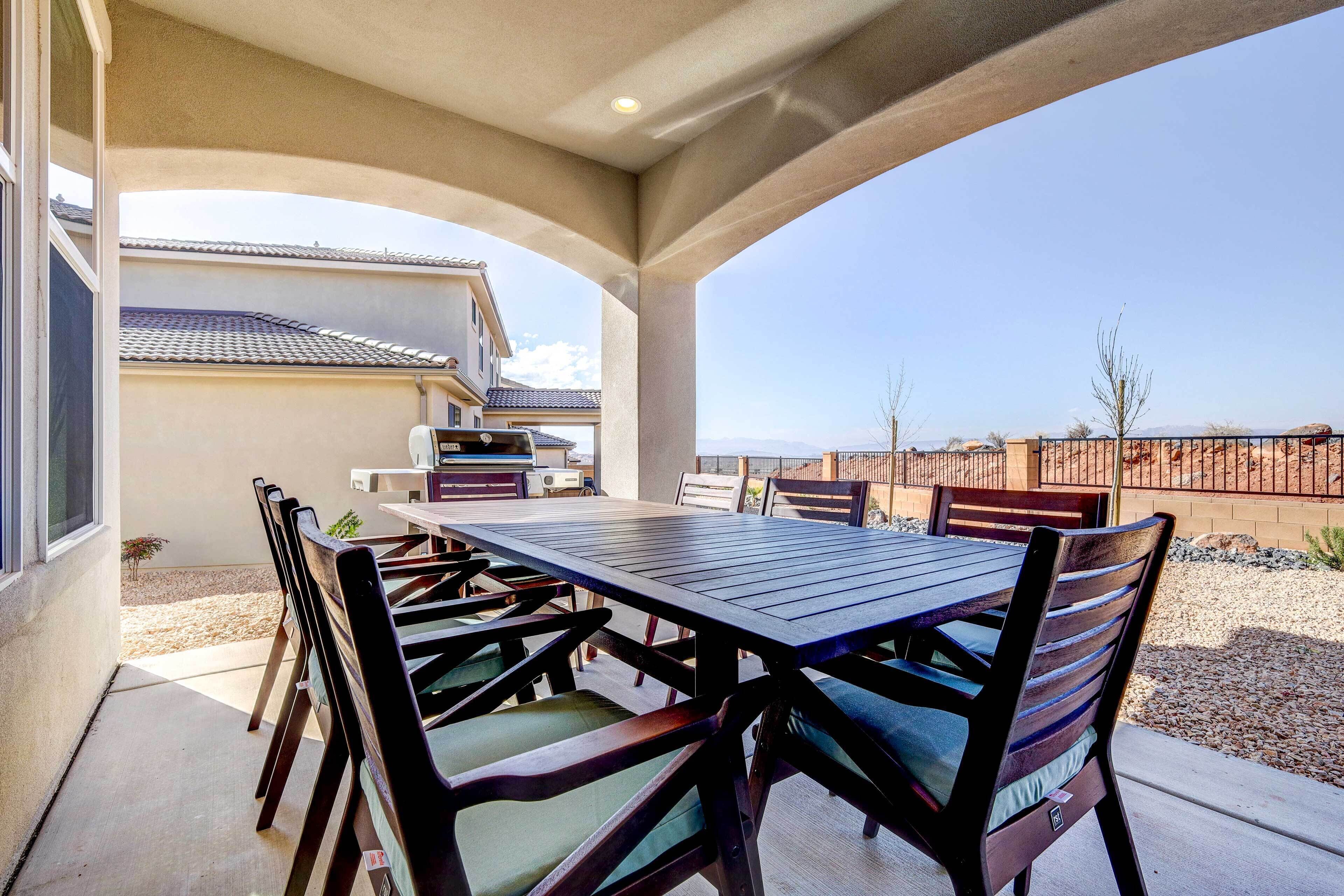 Une terrasse extérieure avec une table et des chaises, un espace abrité et une vue sur une maison en arrière-plan.
