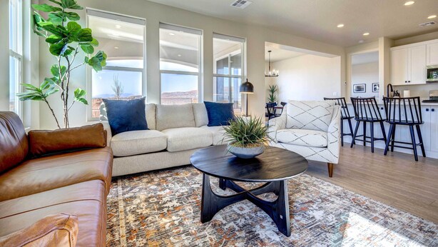 A modern living room with a sofa, a coffee table, and a dining area with chairs.