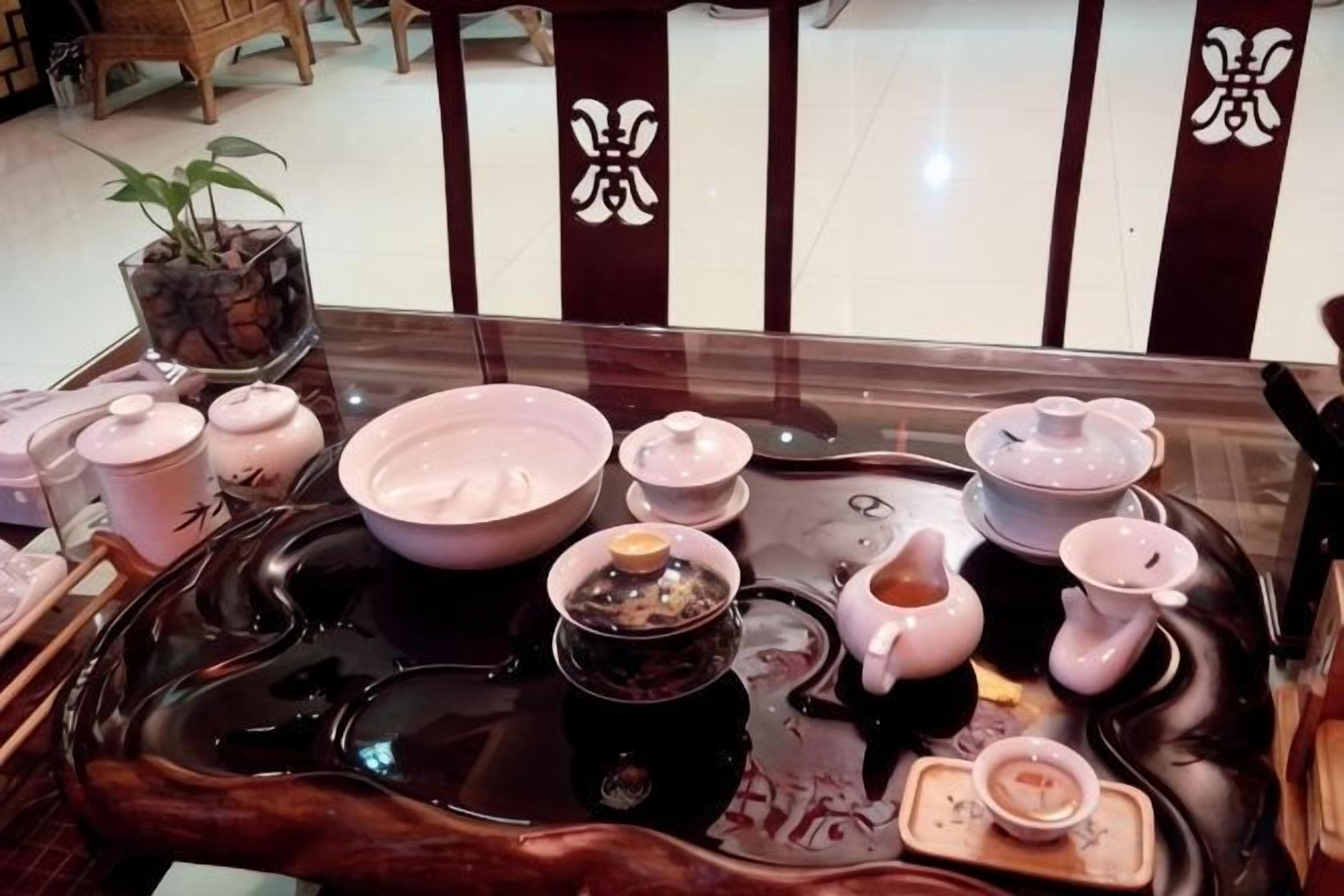 Una mesa de comedor con tazas de té y café, un juego de té y una bandeja.