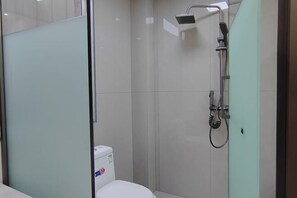 Un bagno moderno con cabina doccia in vetro, doccia e water.