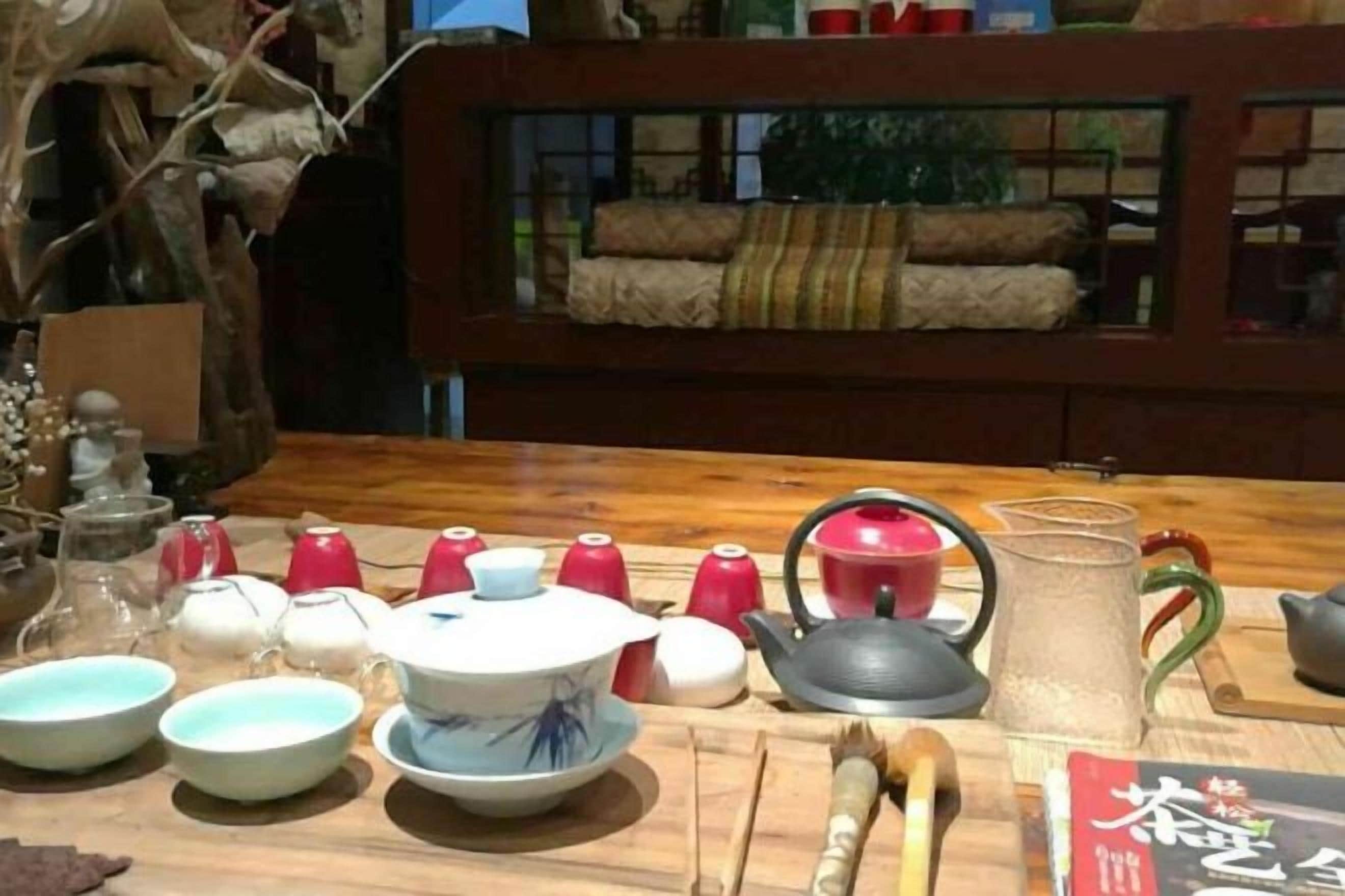 A dining table with various dishes, a teapot, and a book.