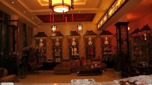 A cozy lobby with a sofa, bookshelves, and a large clock. - Chayu Tinzhu Hotel (Ya'an)