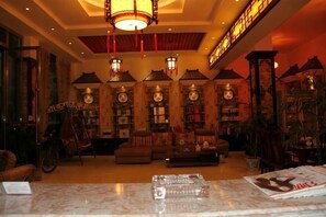 A cozy lobby with a sofa, bookshelves, and a large clock. - Chayu Tinzhu Hotel (Ya'an)