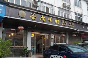 Un hotel con un letrero que muestra su nombre e información de contacto.