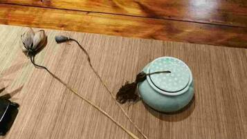 A wooden floor with a ceramic pot and dried flowers.