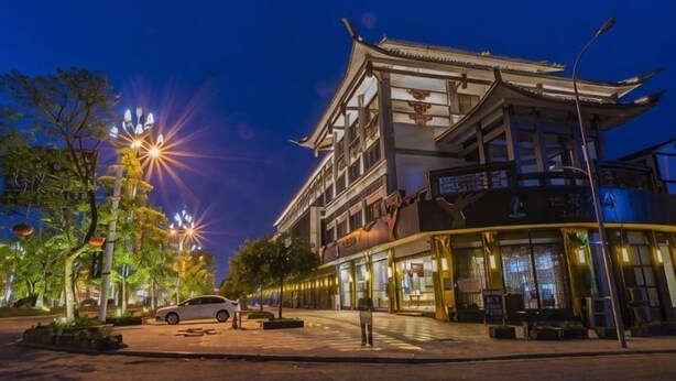 A traditional building with a modern extension, street lamps, and a parked car. - Chayu Tinzhu Hotel (Ya'an)