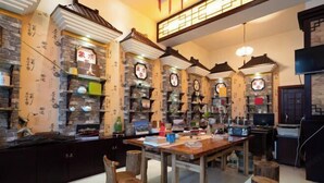 A traditional-style room with wooden furniture, stone walls, and shelves with various items. - Chayu Tinzhu Hotel (Ya'an)