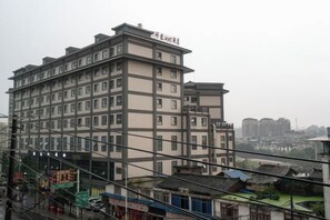 Un hotel de varios pisos con diseño arquitectónico moderno, que destaca por su señalización prominente en la parte superior.