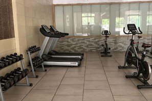 A gym with treadmills, dumbbells, and an exercise bike.