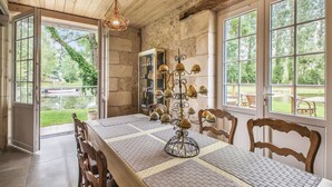 A dining area with a wooden table, chairs, and a decorative light fixture.
