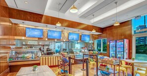 A restaurant with wooden paneling, a kitchen area, and a display case with beverages.