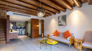 A modern living room with a wooden ceiling, a sofa with orange cushions, a small wooden side table, and a round coffee table.