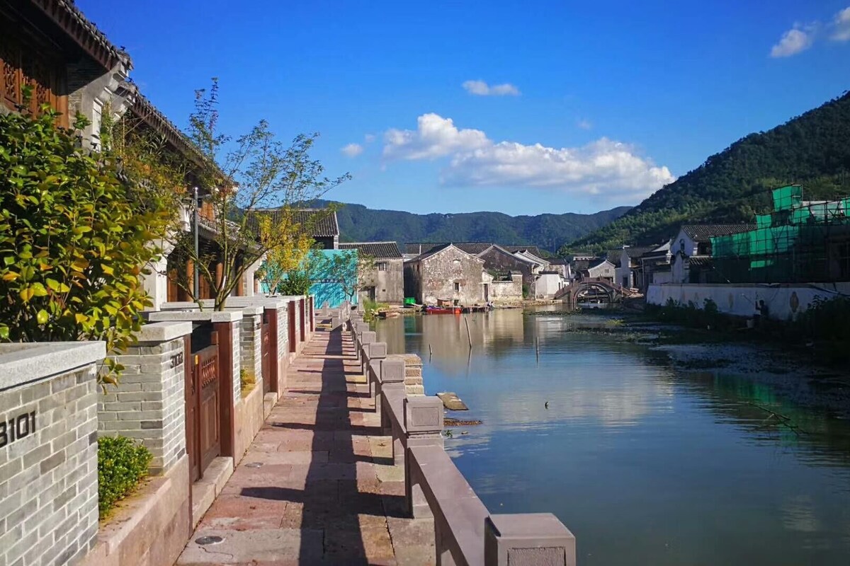 A traditional narrow waterway flanked by old-style buildings with a stone pathway.