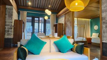 Relax in a cozy room with a comfortable sofa, wooden side table, and large window offering a view of the outdoors.