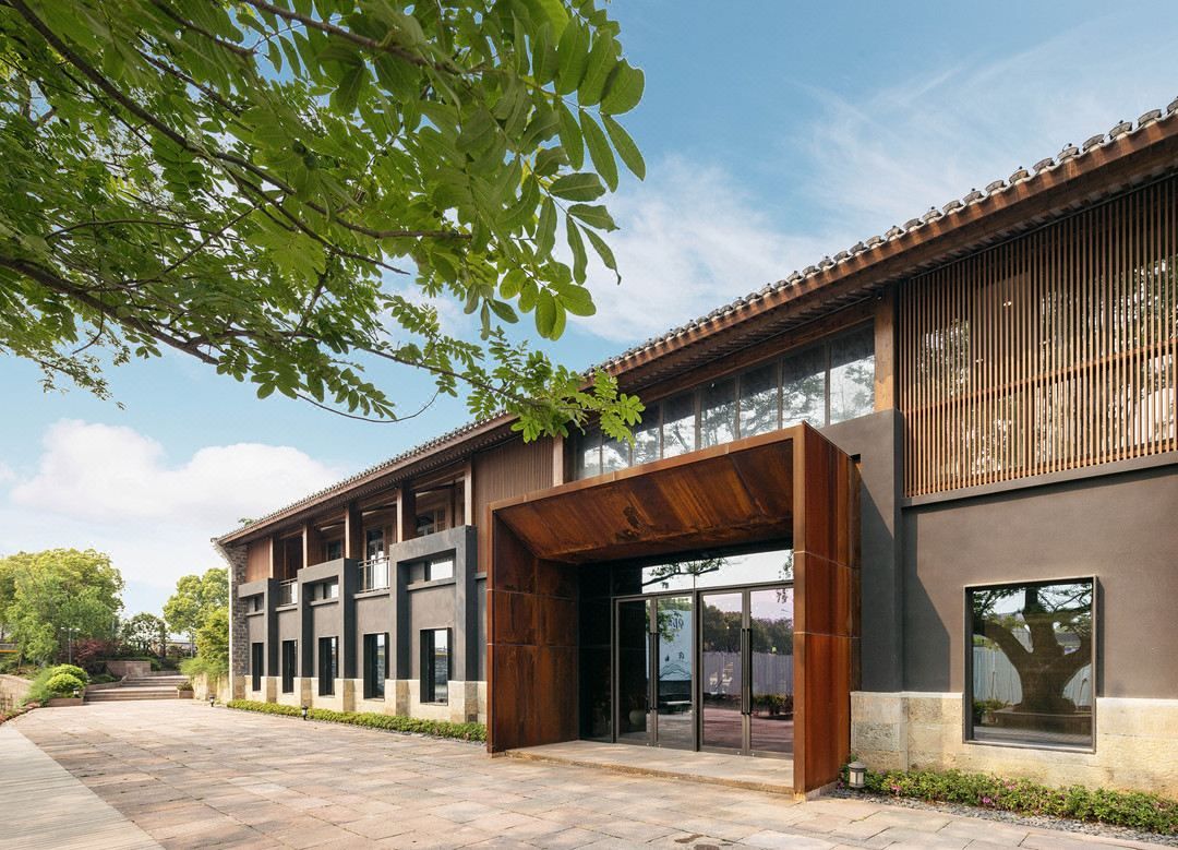 A modern building with a large entrance, multiple windows, and a covered area.