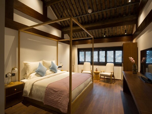 A bedroom with a four-poster bed, bedside tables, a desk, chairs, and a window with patterned shutters. - Blossom Hill Hotel Ningbo Hanling (Ningbo)