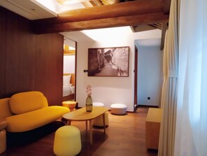 A modern hotel room with a yellow sofa, a wooden coffee table, and a painting on the wall. - Blossom Hill Hotel Ningbo Hanling (Ningbo)