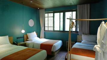 A hotel room with three beds, a wooden ceiling, a large window with curtains, and a hanging rack.