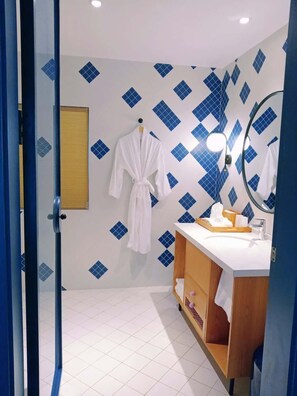 A bathroom with a white sink, a wooden vanity, a mirror, and a blue and white tiled wall. - Blossom Hill Hotel Ningbo Hanling (Ningbo)
