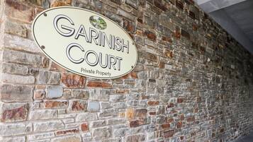 A brick wall with a sign that reads "Garinish Court Private Property."