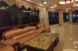 Un amplio salón con un gran sofá de cuero y una mesa de centro de mármol.