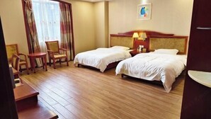 Une chambre d’hôtel avec deux lits, un bureau, une chaise et une fenêtre avec des rideaux.