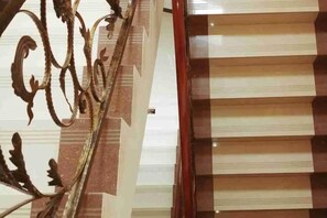 Una escalera con barandilla de metal y piso de diseño a cuadros.