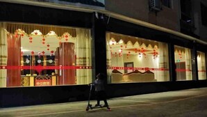 Un bâtiment doté de grandes fenêtres décorées de lanternes rouges et d’une enseigne sur laquelle on peut lire « 中公教育 ».