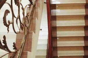 Una escalera con barandilla de metal y pared decorada.