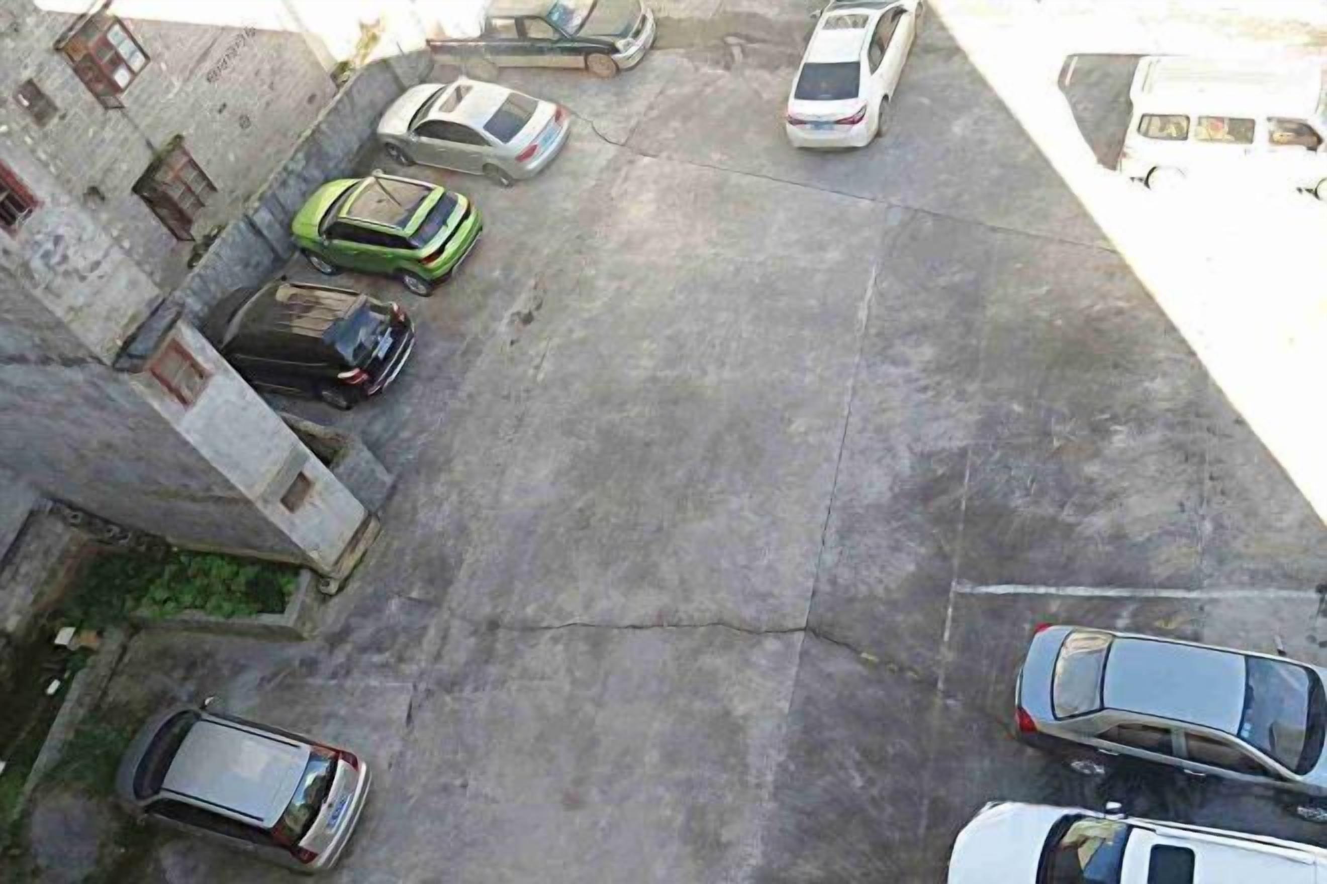Μια αεροφωτογραφία ενός χώρου στάθμευσης με πολλά αυτοκίνητα που είναι σταθμευμένα σε σειρές.