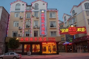 Un hotel de varios pisos con letreros que indican un centro de negocios y un restaurante.
